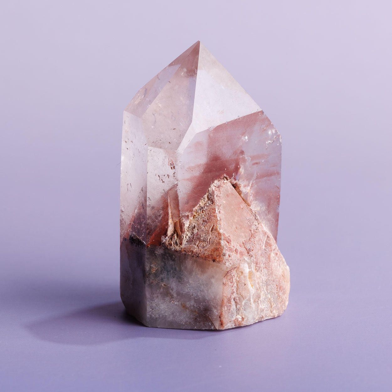 Red phantom quartz crystal freeform on a purple background