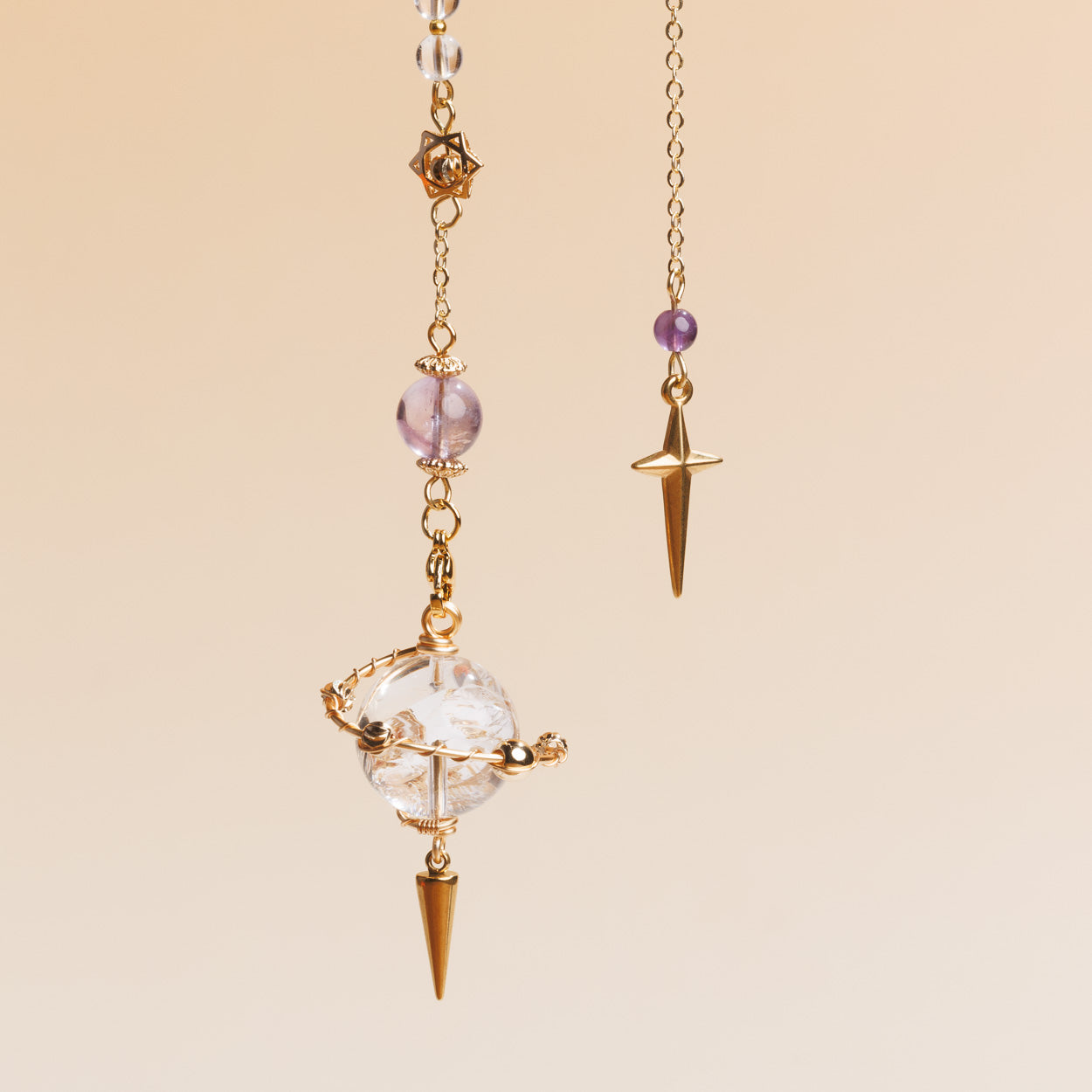 Crystal pendulum with gold accents on a beige background