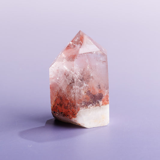 Red phantom quartz crystal freeform on a purple background