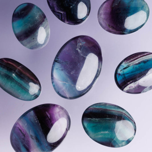 Close-up of multicolored oval stones on a light purple background